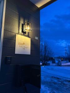 a light on the side of a building with a sign at Villa Shigin in Nakafurano