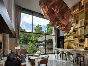 a living room with a large glass wall at L'Esquisse Hotel & Spa Colmar - MGallery Collection in Colmar