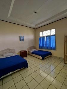 a bedroom with two beds and a window at Villa Mega molek in Pondok Cipaseban