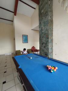 a man is playing a game of pool on a pool table at Villa Mega molek in Pondok Cipaseban
