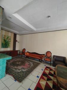 a living room with chairs and a couch and a rug at Villa Mega molek in Pondok Cipaseban
