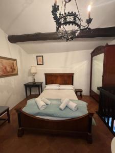 a bedroom with a bed and a chandelier at Locanda Motto del Gallo in Taverne