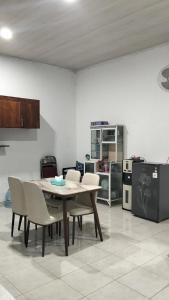 a kitchen with a table and chairs in a room at Homestay Karimun in Grogol
