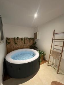 a large bath tub in a room with a ladder at Studio Tulum - jacuzzi privé - face à la mer in Tartane