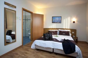 a bedroom with a bed with a bag on it at Tulip Inn Padova in Padova +54 photos