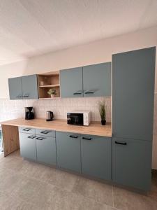 a kitchen with blue cabinets and a counter with a microwave at A2rooms in Lehnin