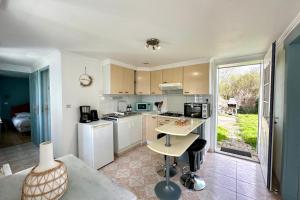 a kitchen with white appliances and a table in a room at Escapade détenteSt-Valery & Le Crotoy à 15 min in Noyelles-sur-Mer