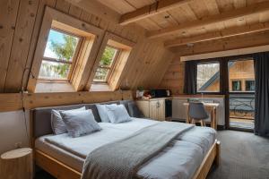 a bedroom with a bed in a wooden cabin at Chocholowska Zohylina pokoje in Chochołów