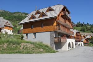 a large house with a gambrel roof on a mountain at Chalets de Praroustan by Actisource in Pra-Loup