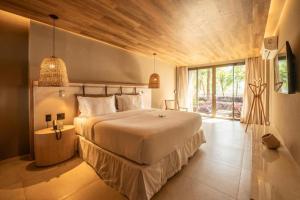 a bedroom with a large bed and a large window at Hamares Boutique Hotel in Fernando de Noronha