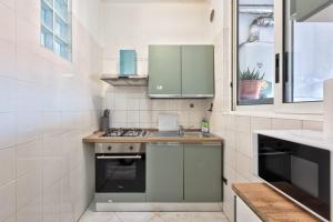 a small kitchen with green cabinets and a sink at Apt Venice City in Mestre