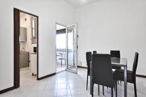 a dining room with a table and black chairs at Apt Venice City in Mestre +17 photos