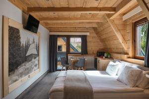 a bedroom with a large bed in a wooden house at Chocholowska Zohylina pokoje in Chochołów