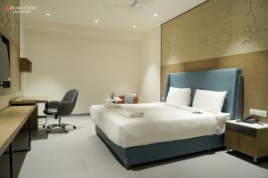 a hotel room with a large bed and a desk at Hotel Shubham Prestige RC Puram in Lingampalli +13 photos