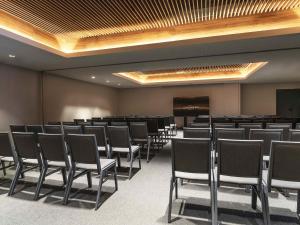 a conference room with rows of chairs and a screen at Costanero Hotel Montevideo - MGallery Collection in Montevideo +125 photos