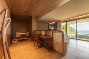 a living room with a table and a view of the ocean at Hamares Boutique Hotel in Fernando de Noronha