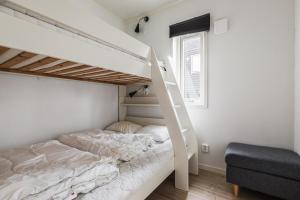 ein Schlafzimmer mit einem Etagenbett und einer Leiter in der Unterkunft Parkstigens Lägenheter in Funäsdalen