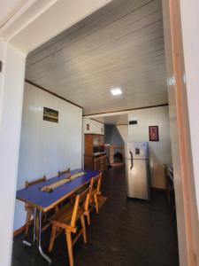 a dining room with a blue table and a refrigerator at Casa Rincón Del Viajero in Eldorado