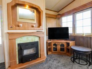 a living room with a fireplace and a television at The Granada at Argraig in Holyhead