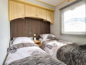 a bedroom with two beds and a window at The Granada at Argraig in Holyhead