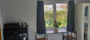 a window with blue curtains and a table and a table with a microwave at The Annexe in Kirkcudbright