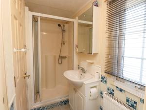 a white bathroom with a sink and a shower at The Granada at Argraig in Holyhead +15 photos