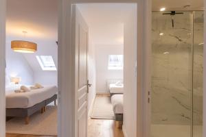 a bathroom with two beds and a glass shower at Le Grenier cocoon in Romorantin
