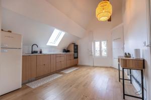 a kitchen with wooden floors and a white refrigerator at Le Grenier cocoon in Romorantin