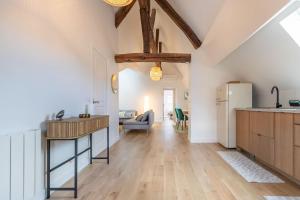 a kitchen and living room with a table and a refrigerator at Le Grenier cocoon in Romorantin