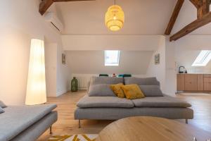 a living room with a couch and a table at Le Grenier cocoon in Romorantin +7 photos