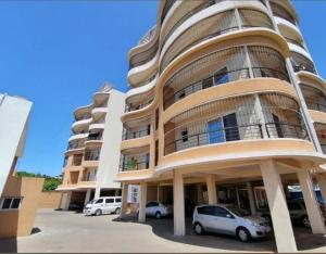 a large building with cars parked in front of it at Seaview SS palm terrace serviced apt-nyali in Mombasa