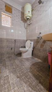 a bathroom with a toilet and a sink at New Suraj Inn - Nestled near Hadimba Temple ! Rooftop Cafe ! Private Parking in Manāli +33 photos