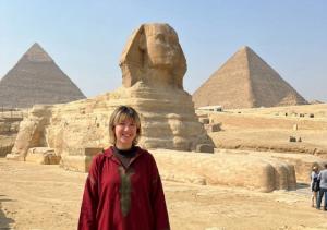 a woman standing in front of the pyramids at HK Pyramids Guest House Hospitality& Kindness in Cairo