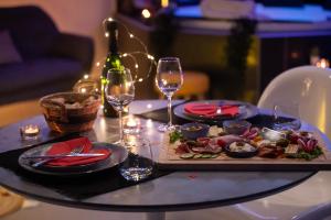 a table with a plate of food and glasses of wine at Lasuite55 in Istres