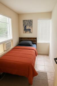 ein Schlafzimmer mit einem Bett mit einer orangefarbenen Decke in der Unterkunft Cabana in Miami