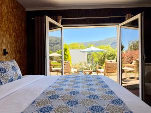a bedroom with a bed and a view of a patio at Casa Carvalhal - Adults Only in Góis