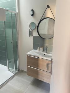 a bathroom with a sink and a mirror at Les Paquebots - Hôtel & Restaurant in Port-Vendres