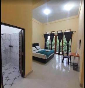 a bedroom with a bed and a walk in shower at The Sanduk Inn in Rantepao