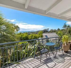 a balcony with two chairs and a table on it at Hot Tub Seaview Chalet 12 in Waiheke Island