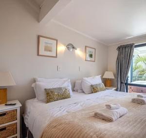 a bedroom with a large bed with towels on it at Hot Tub Seaview Chalet 12 in Waiheke Island