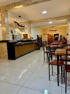 a man standing at a counter in a restaurant at Hotel Miranda Maracaju in Maracaju