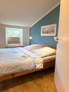 a bedroom with a large bed with a window at Backhuus 3 in Fehmarn