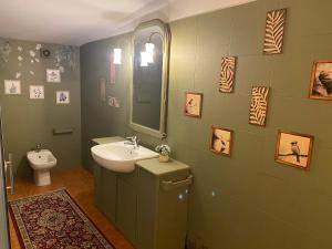 a green bathroom with a sink and a toilet at Relais Le Folaghe in Ladispoli +37 photos
