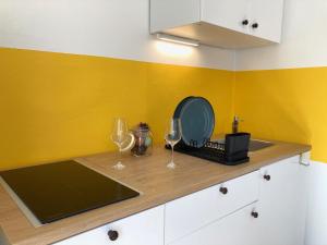 a kitchen with two glasses and a counter with yellow walls at Casa Dante in Gradisca dʼIsonzo +14 photos