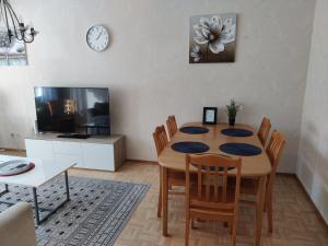 a dining room with a table and chairs and a tv at Yyterin portti in Pori +6 photos