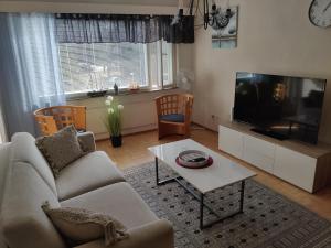 a living room with a couch and a flat screen tv at Yyterin portti in Pori