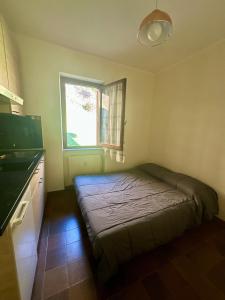 a bedroom with a bed in a kitchen with a window at Il mini rifugio di Pietro in Miroglio