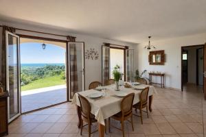 a dining room with a table and a view of the ocean at La caza papangues in Sainte-Suzanne
