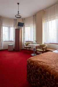 a hotel room with a bed and a table and windows at Hotel Anka in Słubice