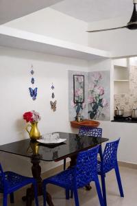 a dining room with a black table and blue chairs at Vasan villa 2BHK in Pondicherry